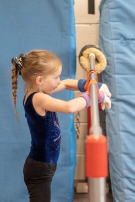 Young gymnast at a padded training bar